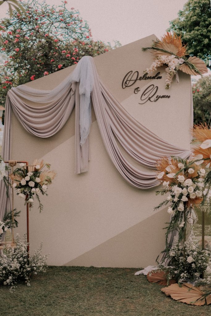 the stunning wedding backdrop wit floral and fabric setup