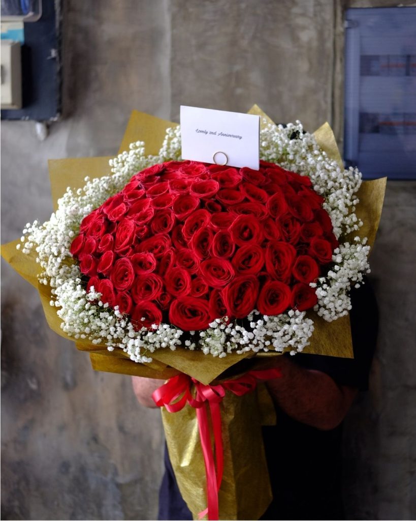 big hand bouquet red roses and baby breath anniversary flowers meaning